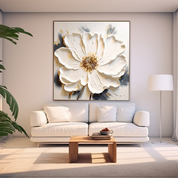 Living room with a large floral painting on the wall above a white sofa.