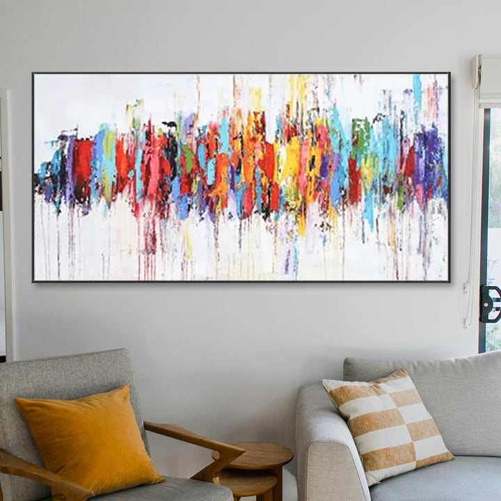 Colorful abstract painting on a wall in a living room with a sofa and armchair.