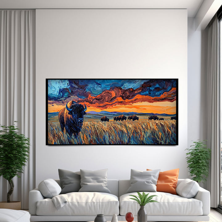 Framed artwork of a bison in a field with a sunset sky above a white sofa.
