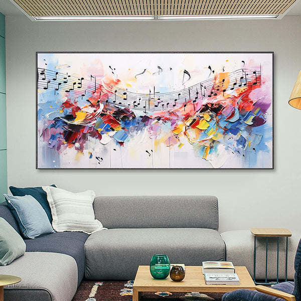 Colorful abstract painting of musical notes above a gray sofa in a living room.