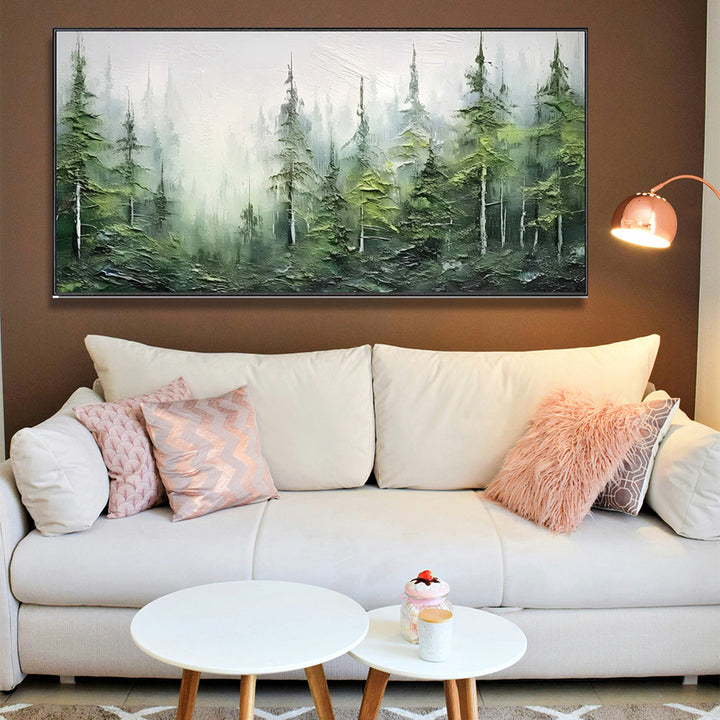 Living room with a white sofa, decorative pillows, and a forest painting on the wall.