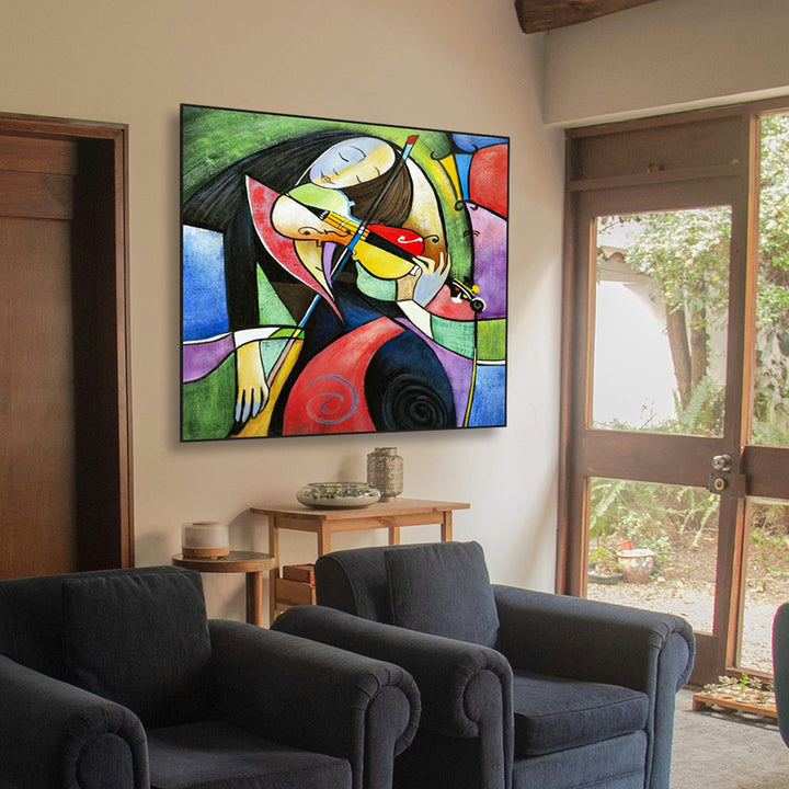 Colorful abstract painting on a wall in a living room with dark gray chairs.