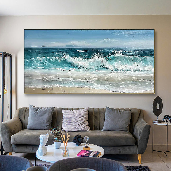 Living room with a large ocean wave painting on the wall above a gray sofa.
