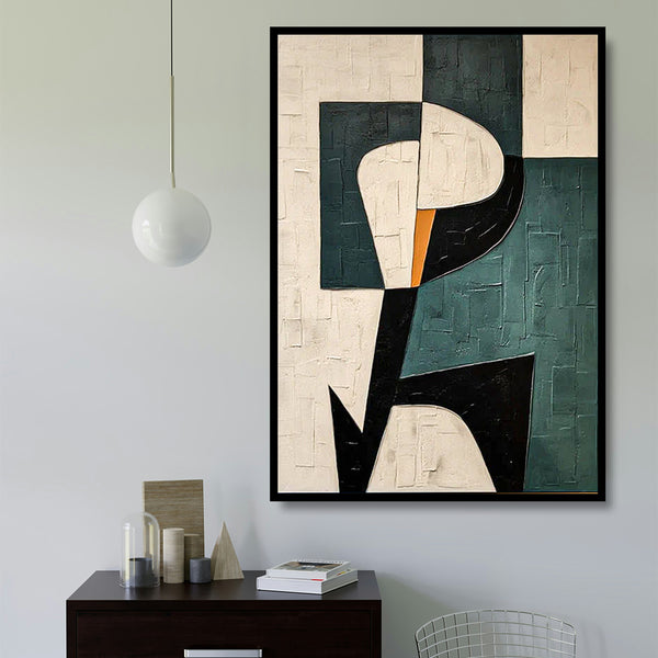 Abstract art piece on a wall above a desk with decor items.