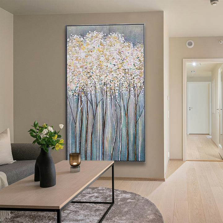 Living room with a large abstract painting of trees on a wall, a coffee table with decor items, and a sofa.
