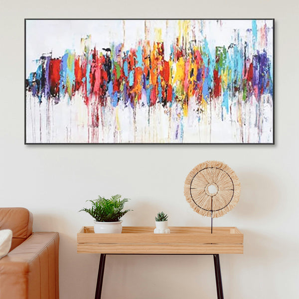 Colorful abstract painting on a wall above a wooden console table with decorative items.