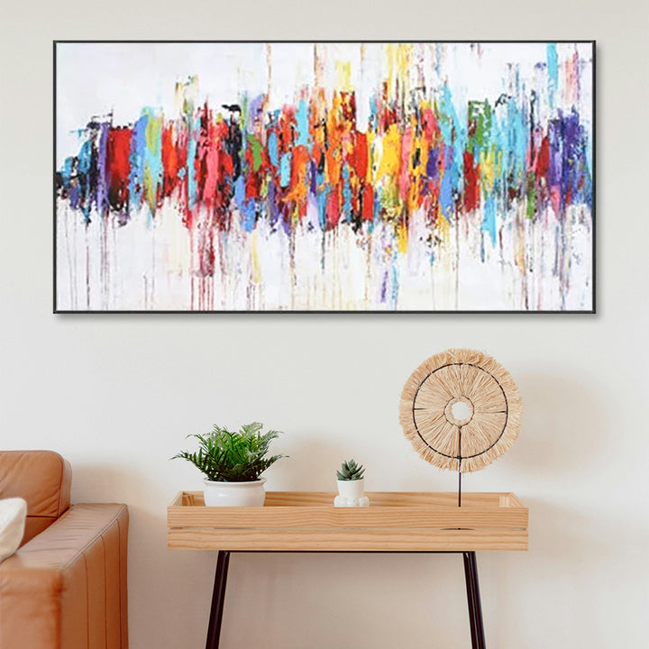 Colorful abstract painting on a wall above a wooden console table with decorative items.
