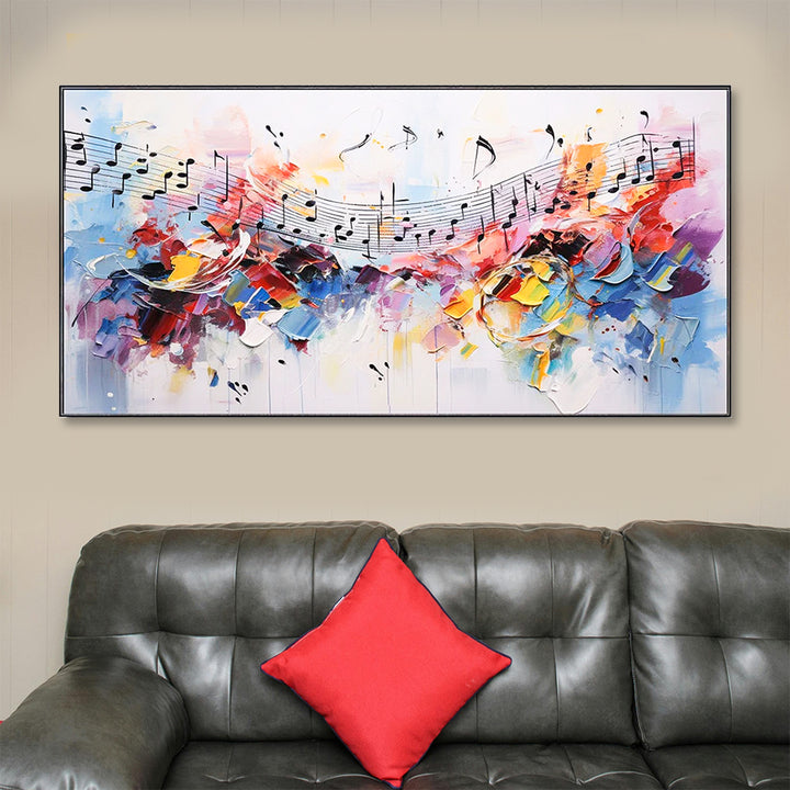 Colorful abstract painting of musical notes above a gray sofa with a red pillow.