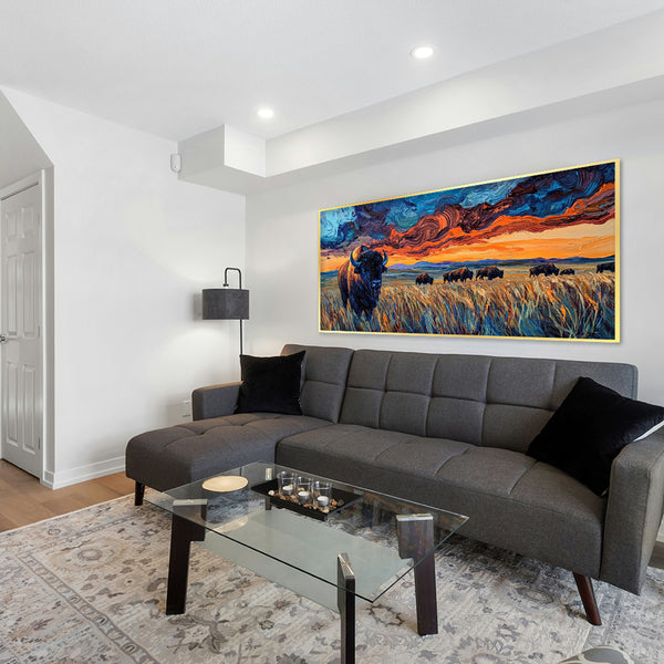 Living room with a gray sectional sofa, glass coffee table, and a large painting of bison on the wall.